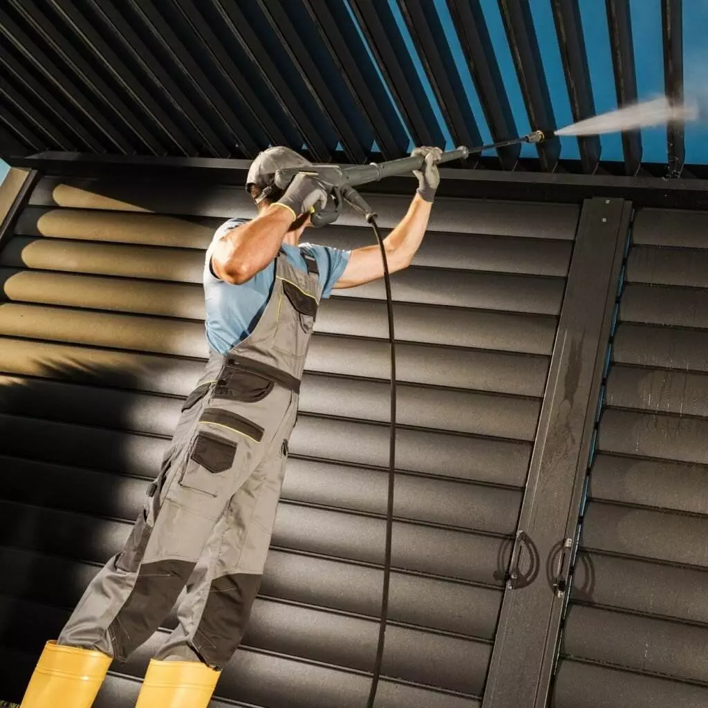 Commercial Pressure Washing Services page image of man pressure washing a storage unit